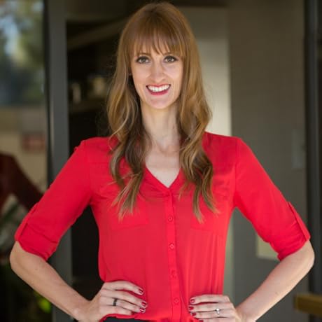 Headshot of woman with red shirt and long wavy auburn hair.