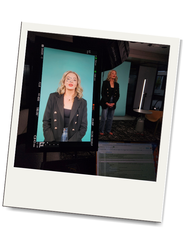 Polaroid-style image of a studio from behind the camera where Danica Bunch is presenting. She has a black blazer and wavy blonde hair and is standing in frond of a teal studio backdrop.